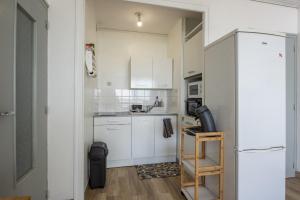 een kleine keuken met witte kasten en een koelkast bij Venez profiter de ce bel appartement situe a Saint Hilaire de Riez in La Parée Preneau