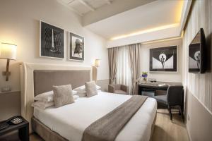 una camera d'albergo con letto e scrivania di Condotti Palace a Roma