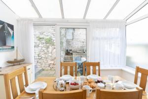 een eetkamer met een tafel en stoelen en een raam bij Apters Hill House in Brixham