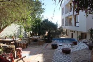 a patio with tables and chairs and a pool at Taghazout Hill Retreat in Taghazout