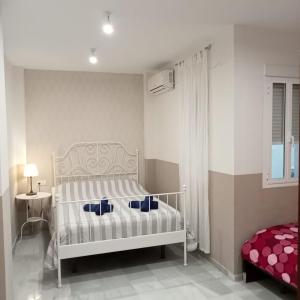 um quarto com uma cama branca com almofadas azuis em Apartamentos centro histórico em Sevilha