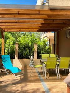 a patio with chairs and a table on a deck at ZEN Apartman Sunshine in Zamárdi