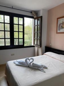 um par de cisnes sentados em cima de uma cama em Hostal Asador Julian em Brunete