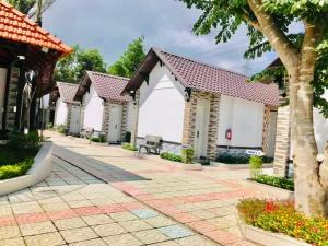 a row of houses with trees and flowers at Nhà Nghỉ TRẦN ĐỨC in Phú Mỹ