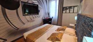 una camera con letto e TV a parete di Hôtel Renaissance a Castres