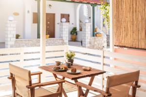 a wooden table and chairs on a patio at Τrilogy Studios in Syvota