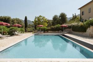 a swimming pool with chairs and umbrellas at La Muccheria in San Vincenzo