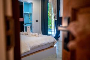 um quarto com uma cama com uma toalha em Merijaan Maldives em Maafushi