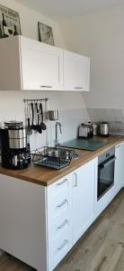 a kitchen with white cabinets and a counter top at Kleine Auszeit Pellworm in Pellworm