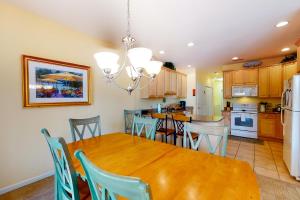 a kitchen and dining room with a wooden table and chairs at Salt Pond -- 13 Skipjack Village in Bethany Beach