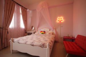 1 dormitorio con 1 cama blanca y 1 silla roja en 萩閣民宿Sara's House走路可到夜市近市區好停車, en Hualien City