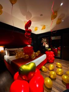 una habitación con globos rojos y dorados y una cama en Hotel Orizzonte, en Giugliano in Campania