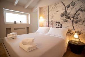 a bedroom with a white bed with towels on it at Time to Be - Luxury Apartments Centro Storico in Peschiera del Garda