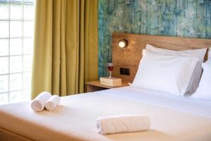a bedroom with a bed with two towels on it at Τrilogy Studios in Syvota