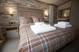 a bedroom with a large bed with towels on it at Appletree Holiday Park in Boston