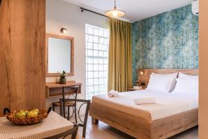 a bedroom with a bed and a table with a bowl of fruit at Τrilogy Studios in Syvota