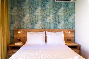 a bedroom with a bed with a painting on the wall at Τrilogy Studios in Syvota