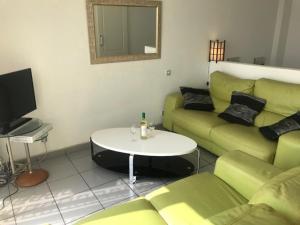 - un salon avec un canapé vert et une table dans l'établissement Villa Marina Apartment, à Benidorm