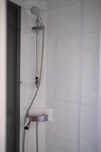 La salle de bains est pourvue d'une douche avec un pommeau de douche. dans l'établissement Mobil Home XXL 4 chambres - Camping Le Barberousse, à Gruissan
