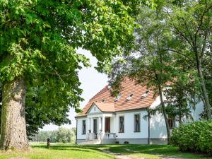 a small white house with a red roof at Dwór Gogolewo nad Wartą in Książ Wielkopolski