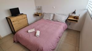 a small bedroom with a bed with a pink blanket at Folitsa a Lovely central House in Kos Town