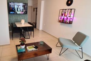 a living room with a table and a chair at Folitsa a Lovely central House in Kos +6 photos