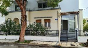 a building with an open door next to a tree at Folitsa a Lovely central House in Kos