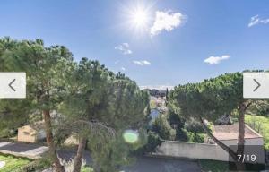 a view of a city with trees and the sun at Montpellier : Jolie studio très calme in Montpellier