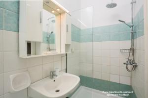 a white bathroom with a sink and a mirror at Anna Apartments Boukari in Boukari