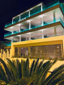 a large yellow building with palm trees in front of it at EUROPA Hotel in Vasto