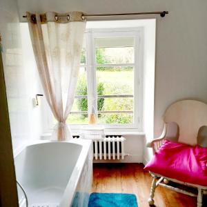 a bathroom with a large tub and a window at Chambres d'Hôtes Couleurs d'Elvine in Coutances