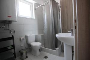 a white bathroom with a toilet and a sink at Stellina's House in Káto Alissós