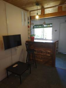 a living room with a piano and a television at La Escondida. Hasta p /6 personas. Parrilla. WiFi in Puerto Pirámides