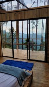 1 dormitorio en una casa del árbol con ventana grande en Latibule Glamping, en La Vega