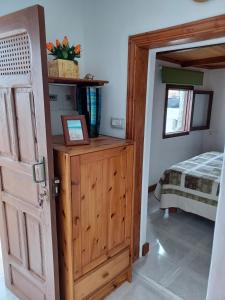 Zimmer mit einer Holztür und einem Bett in der Unterkunft casa cueva a orilla del mar Brisas del Mar in El Escobonal