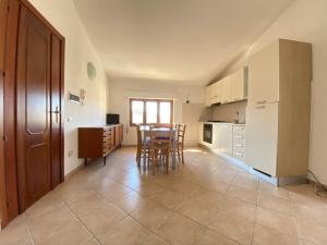 cocina con mesa y sillas en una habitación en Appartamenti dei Giardini, en Muravera