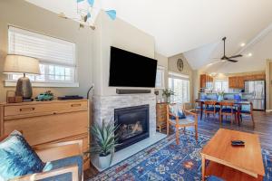 a living room with a fireplace and a flat screen tv at Trees and Tees at Eagle Crest in Redmond