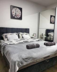 a bedroom with a large bed with two pillows on it at Grey & Sunny Apartments Zaječar in Zaječar