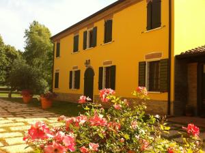 a yellow house with flowers in front of it at Agriturismo Corte Capiluppia in Curtatone