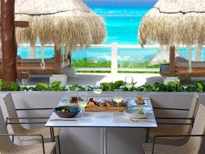 a table with plates of food and glasses of wine at Paradisus Cancun All Inclusive in Cancún +37 photos