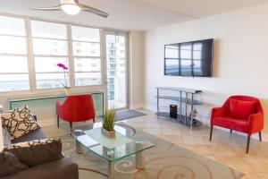 a living room with red chairs and a flat screen tv at Flip Flop Paradise in Hollywood Florida in Hollywood