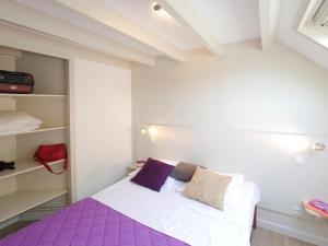 una camera da letto con un letto viola e bianco e scaffali di ULVF Ty an Diaoul a Sarzeau Altre 13 foto