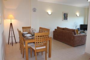 a dining room with a table and chairs and a couch at Casa Jacqueline in Albufeira