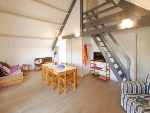 a living room with a table and a staircase at ULVF Ty an Diaoul in Sarzeau