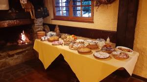 a table with a bunch of pastries on it with a fireplace at Residence Mirage in Oga