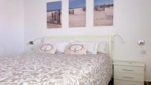 ein Schlafzimmer mit einem Bett mit vier Bildern an der Wand in der Unterkunft Turquesa Powered by SolymarCalma in Costa Calma