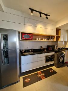 uma cozinha com um frigorífico de aço inoxidável e uma máquina de lavar louça em Loft Novo e Sofisticado em frente a Av José Munia Unique Residence em São José do Rio Preto