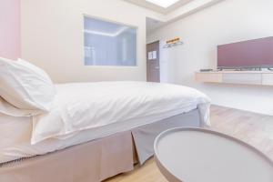 Ένα ή περισσότερα κρεβάτια σε δωμάτιο στο WOW Penghu Homestay