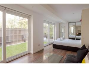 1 dormitorio con cama y ventana grande en Pass the Keys - King's Cross modern flat with Sunny Garden, en Londres