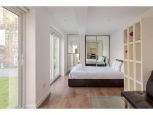 a bedroom with a bed and a large mirror at Pass the Keys - King's Cross modern flat with Sunny Garden in London